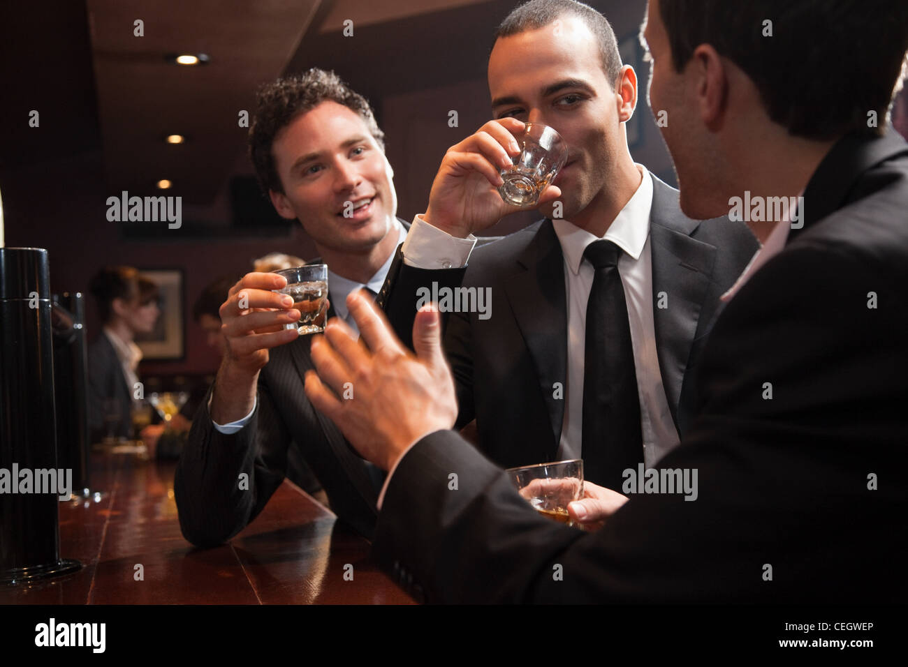 Three businessmen drinking at a bar stock photo alamy