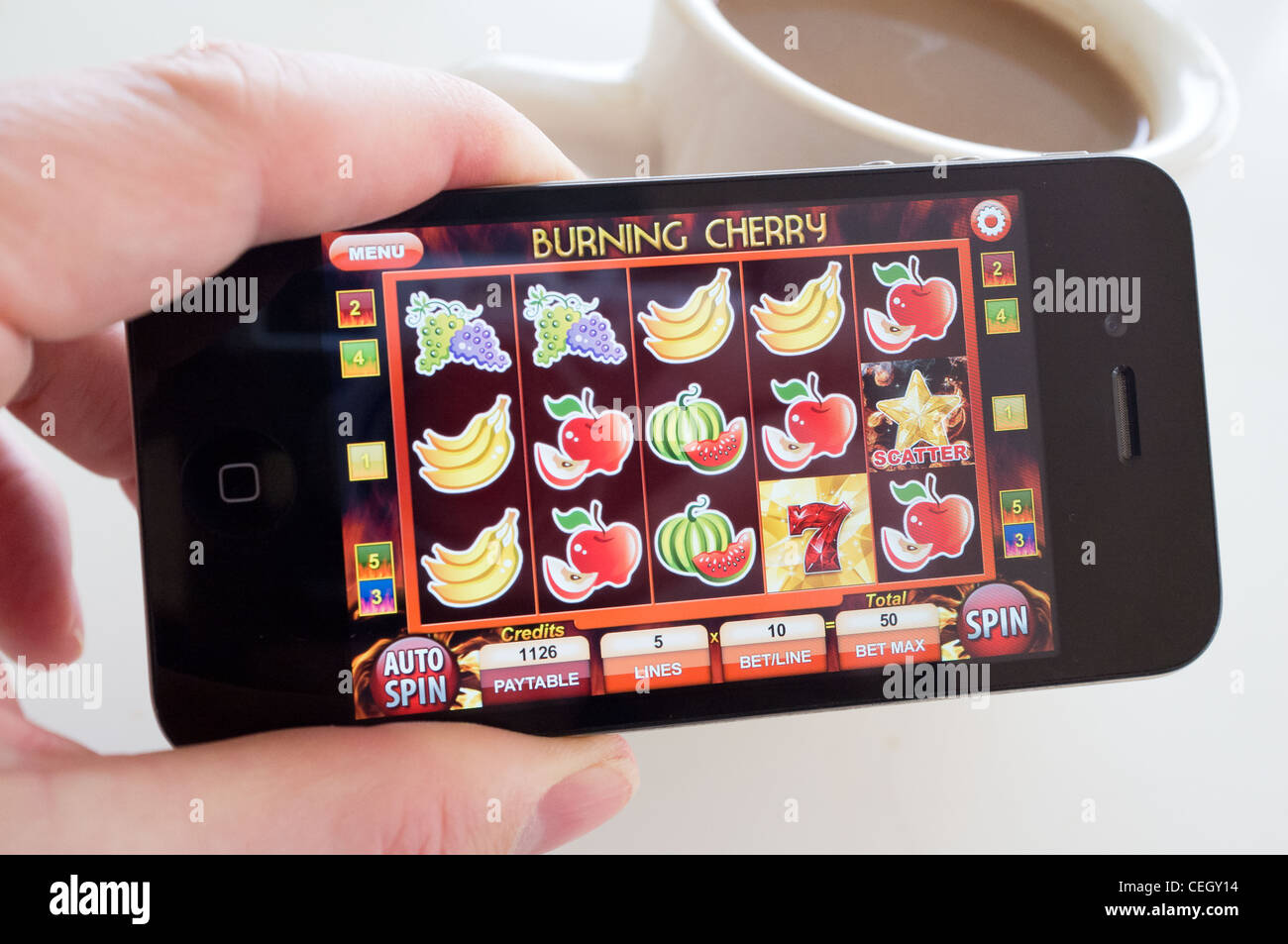 Playing slot machine game on an iPhone 4G smart phone Stock Photo