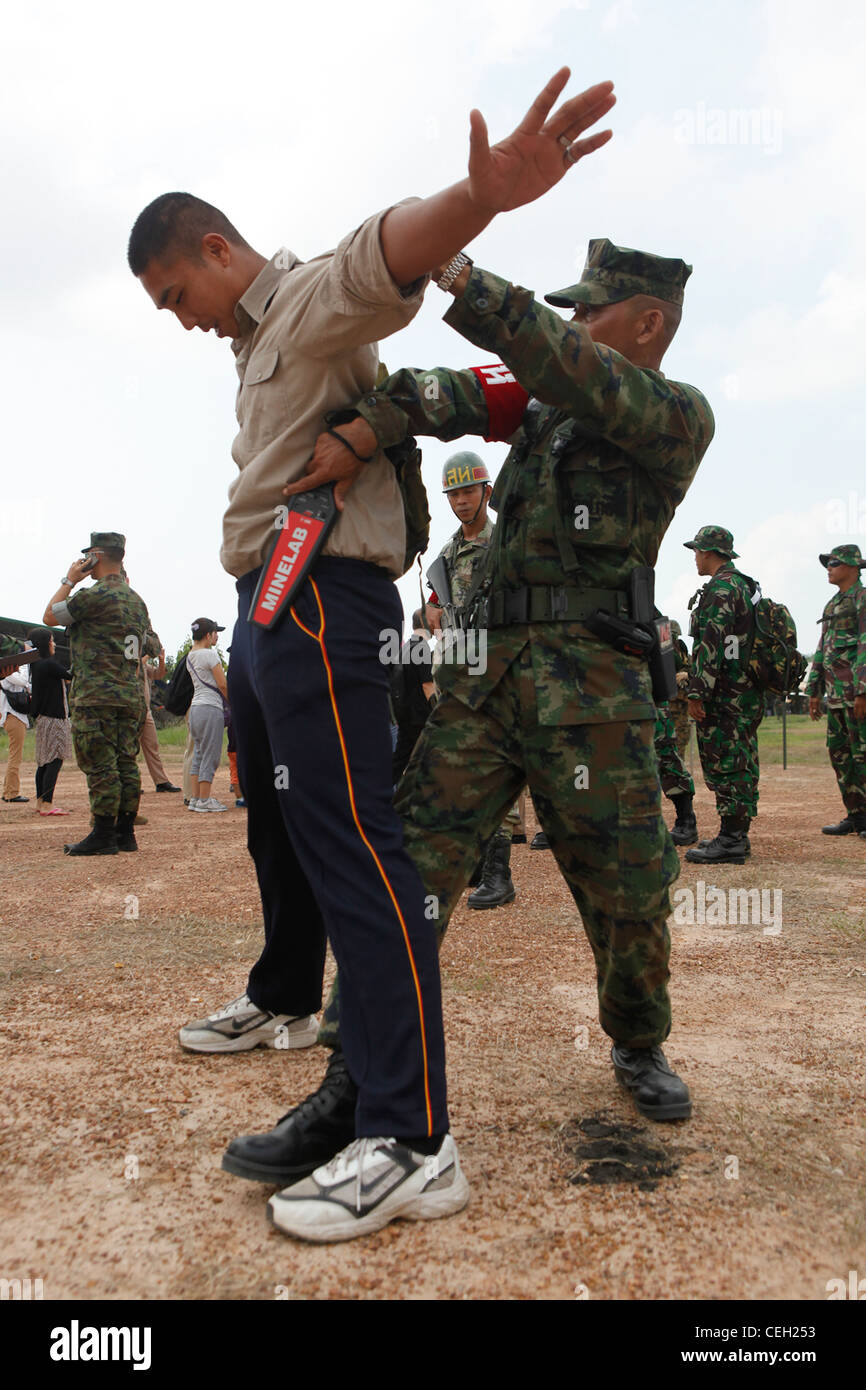 A Royal Thai Marine searches an evacuee at the entry control point during the simulated non-combatant evacuation operation at Rayong, Kingdom of Thailand, Feb. 12, 2012. The Royal Thai Marine Corps, U.S. Marines, Japan Self Defense Forces, Malaysian and Singaporean armed forces all participated in the NEO training during Exercise Cobra Gold 2012. The exercise improves the capability to plan and conduct combined joint operations, building relationships between partnering nations and improving interoperability across the Asia-Pacific Region. Stock Photo