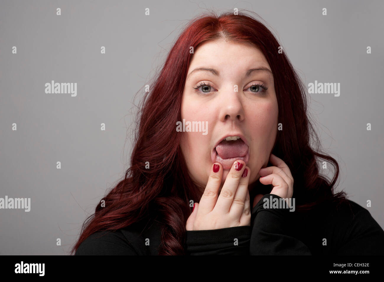 A auburn haired caucasian woman looking and feeling ill sick poorly hungover Stock Photo