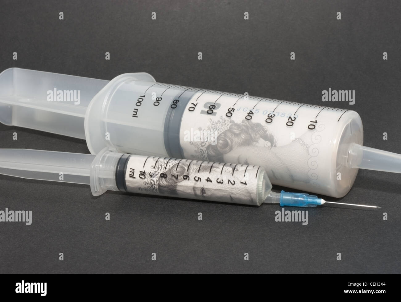 Syringe filled with cash Stock Photo