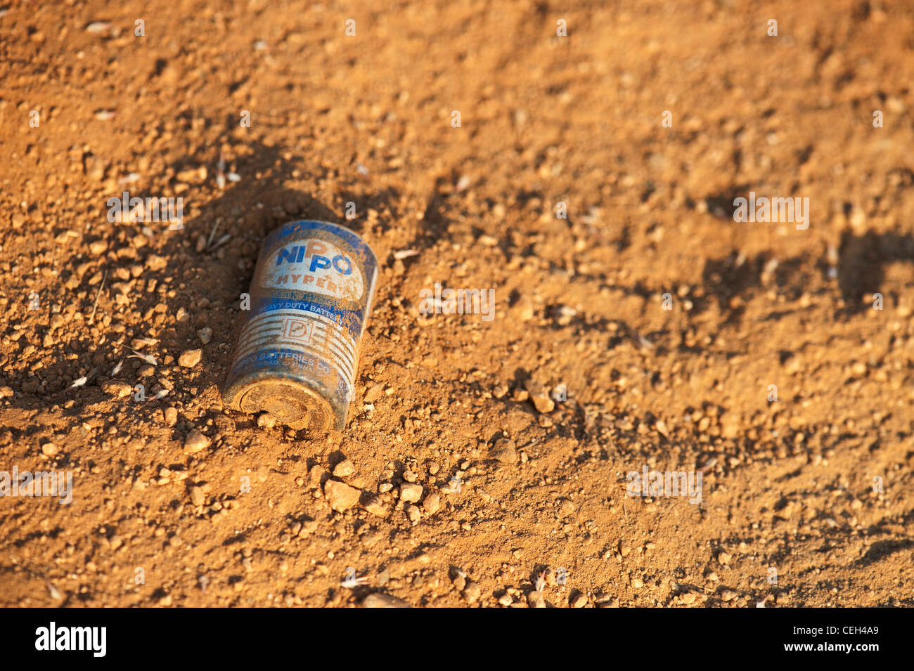 Discarded battery in the earth in the Indian countryside Stock Photo