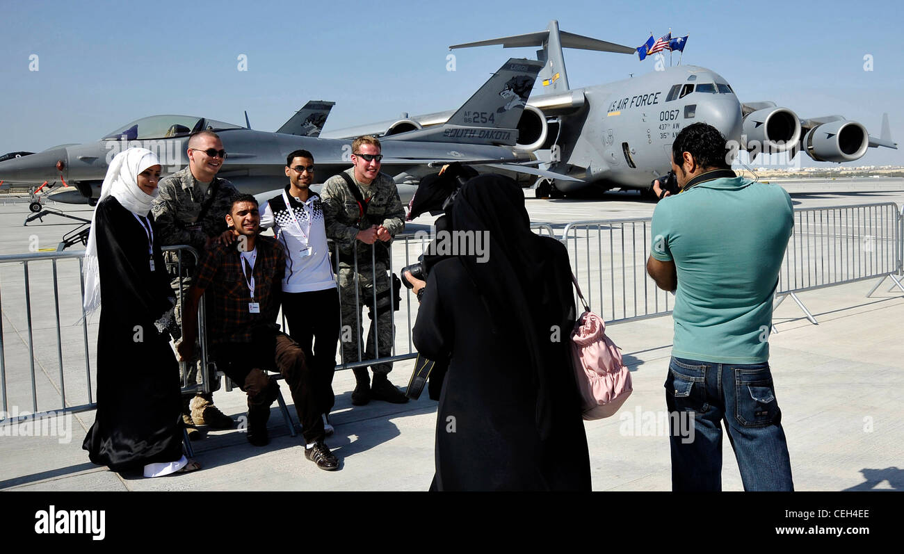 U.S. Air Force Airmen 1st Class Anthony Fox and Brandon Denton, from the 20th Security Forces Squadron, Shaw Air Force Base, S.C., pose for pictures with local Bahrainis while providing security during Bahrain's inaugural airshow, Jan. 23. Stock Photo