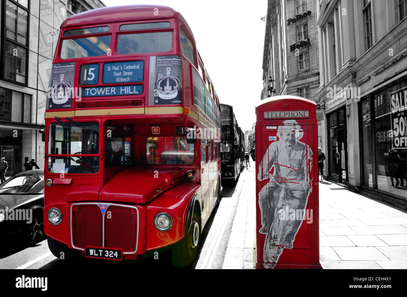 Routemaster bus pacing a classic red telephone box with a graffiti picture of einstein on it. Red popped B&W background Stock Photo