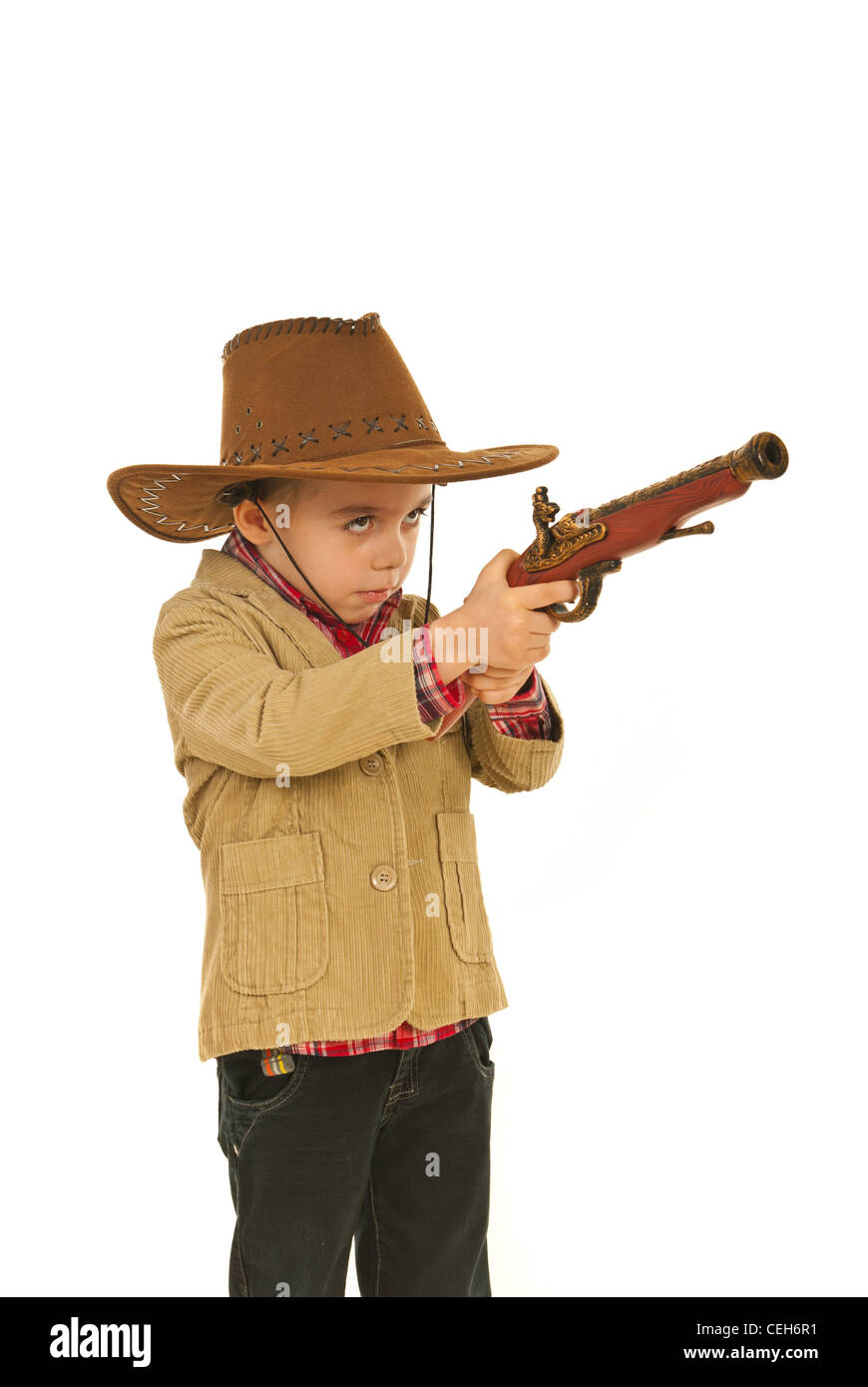 Small cowboy boy with hat playing with gun toy isolated on white background Stock Photo