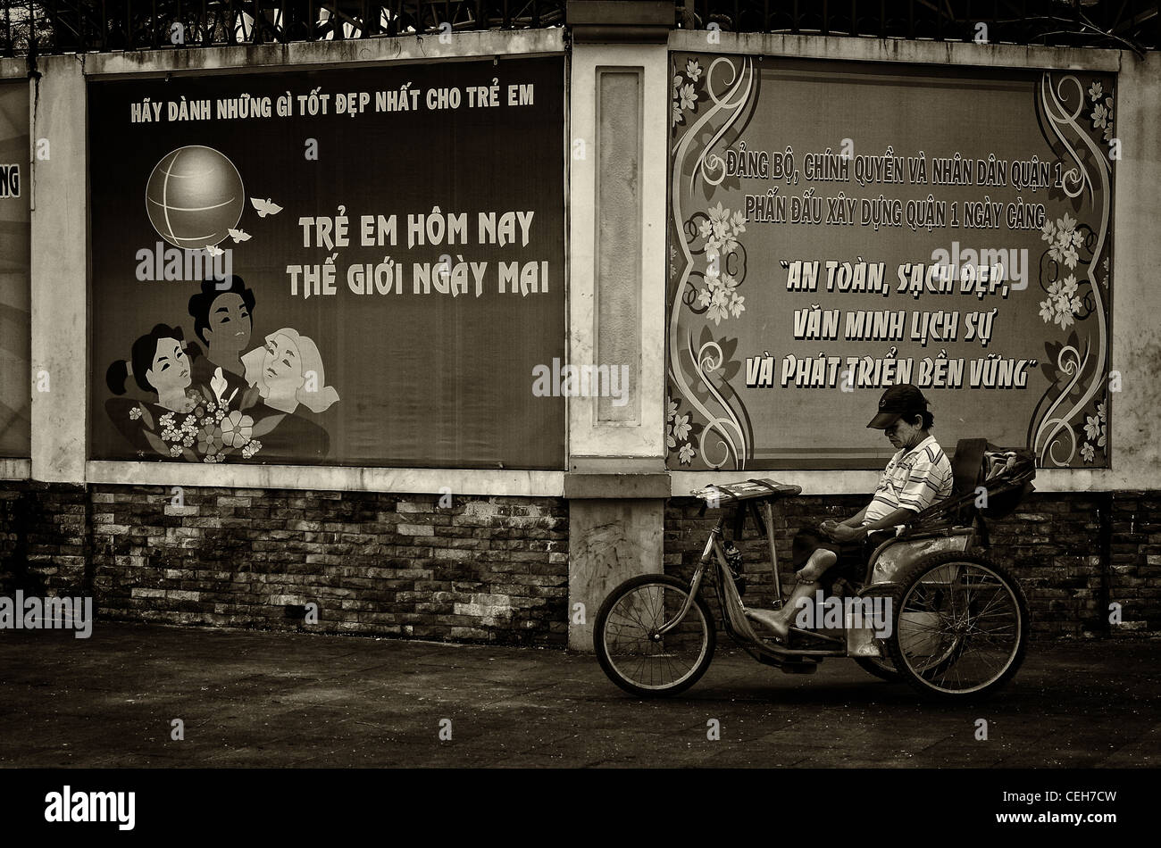 Lottery tickets seller in front of communist propaganda posters in Ho Chi Minh City, Vietnam Stock Photo