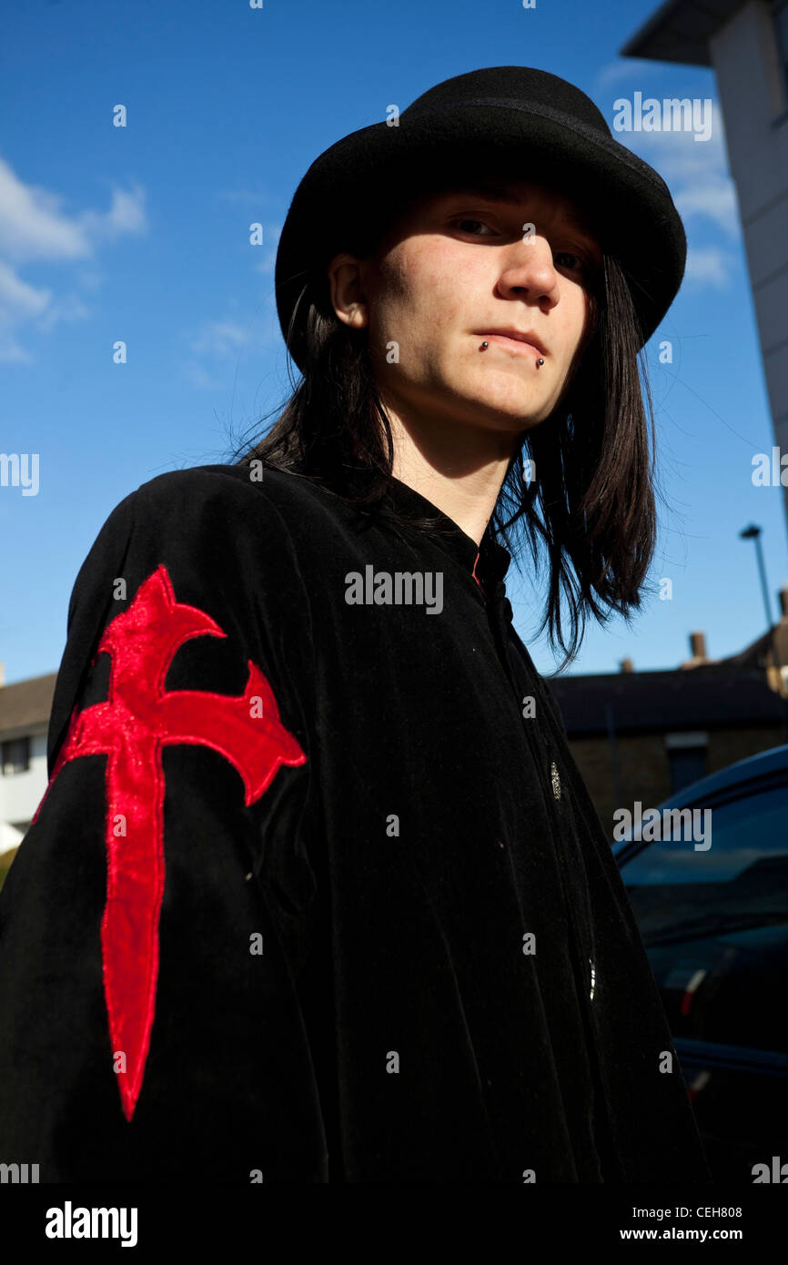 Portrait of a Goth man wearing black cloak with a red cross on it, and a hat, London, England, UK Stock Photo