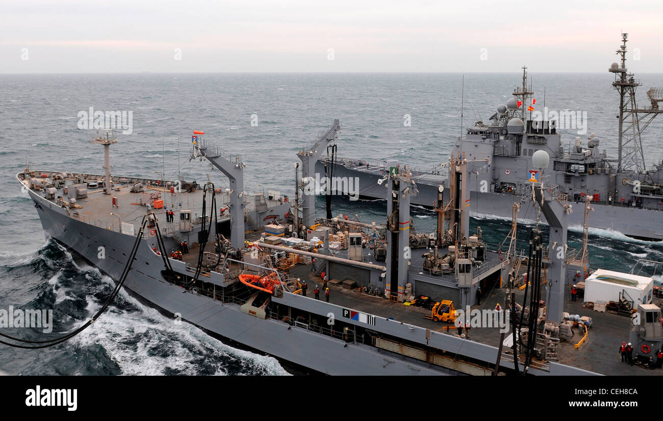 The Military Sealift Command Henry J. Kaiser-class fleet replenishment oiler USNS Patuxent transfers fuel to the Nimitz-class aircraft carrier USS Abraham Lincoln and the Ticonderoga-class guided-missile cruiser USS Cape St. George. Abraham Lincoln and Cape St. George are deployed to the U.S. 5th Fleet area of responsibility conducting maritime security operations, theater security cooperation efforts and support missions as part of Operation Enduring Freedom. Stock Photo