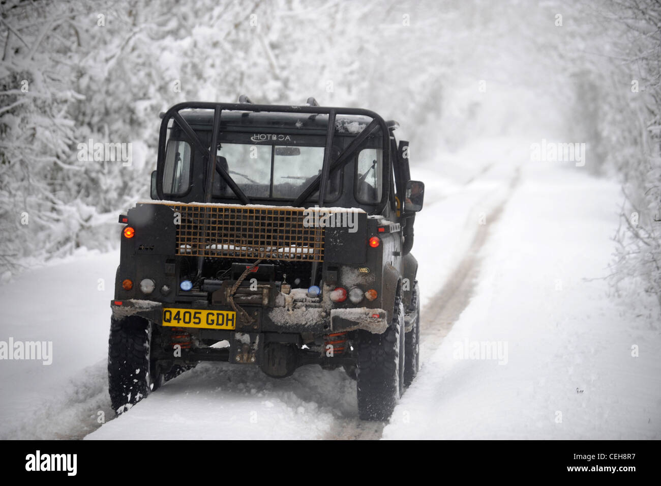 A Land Rover jeep 4x4 on a lane in snowy conditions in Gloucestershire UK Stock Photo