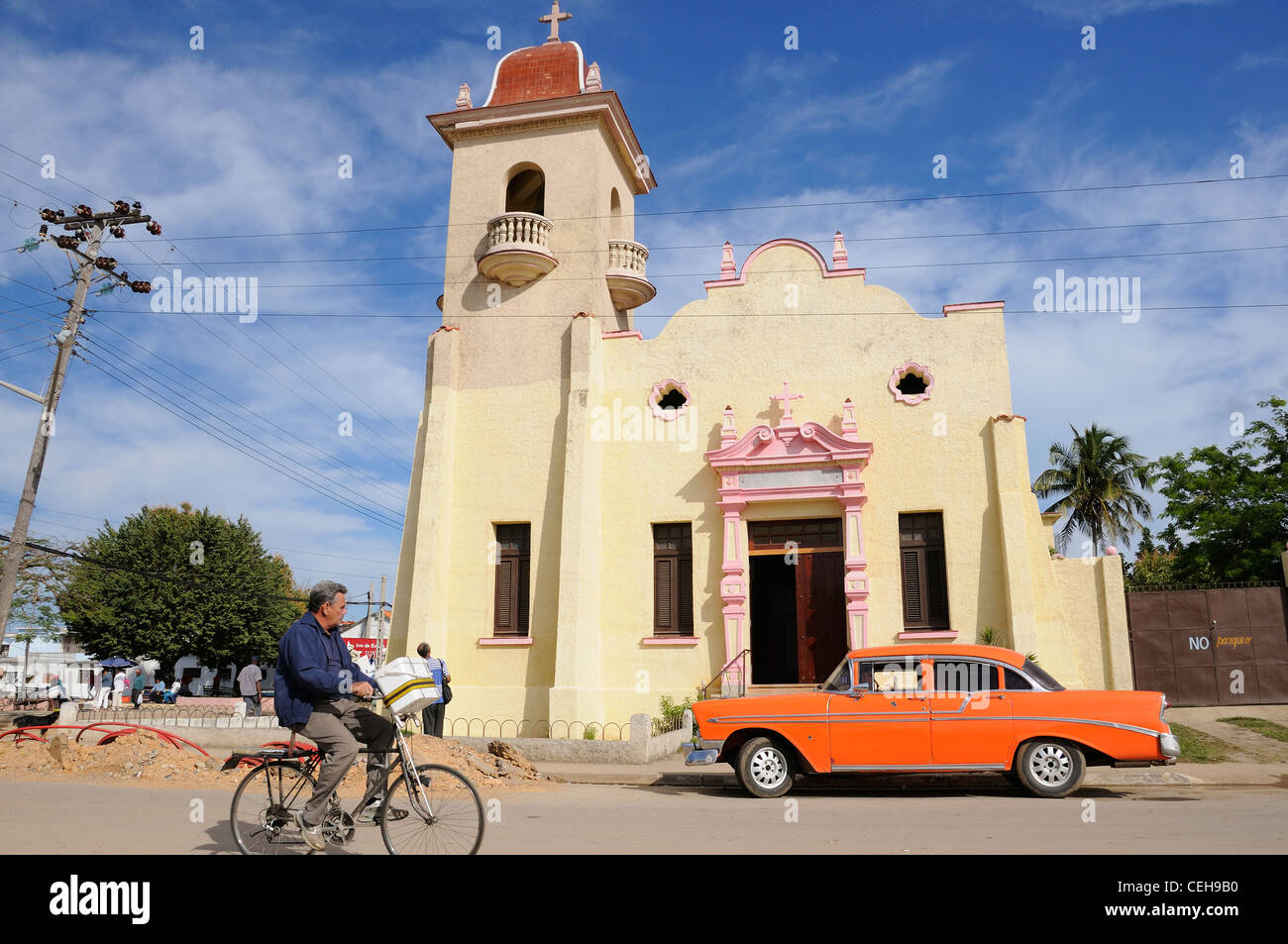 Bike and old car in front of church in Nueva Gerona, Iglesia de Nuestra Senora de los Dolores, Isla de la Juventud, Cuba Stock Photo