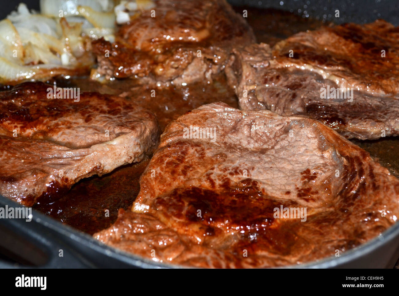 Steak and onions cooking in a fry pan Stock Photo Alamy