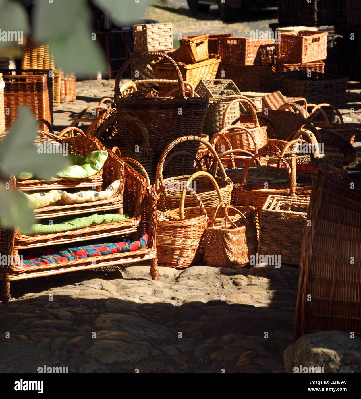 A collection of wicker baskets in bright sunshine inside Chipping Campden market hall, Cotswolds, Gloucestershire, UK Stock Photo