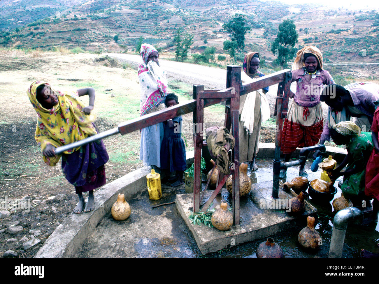 Women collect water from a modern pump well provided by foreign aid in Ethiopia Stock Photo