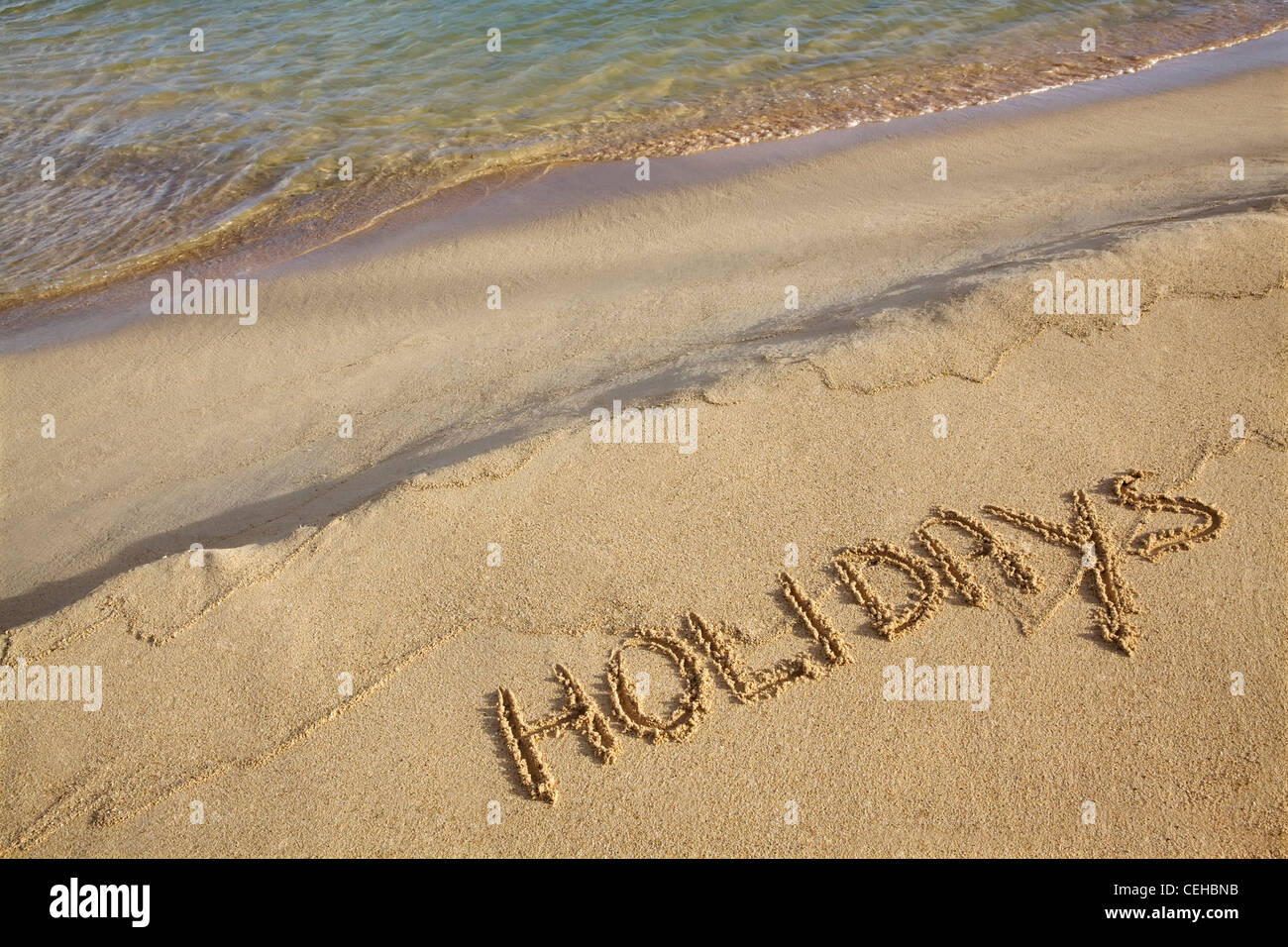 Holidays written in the sand Stock Photo