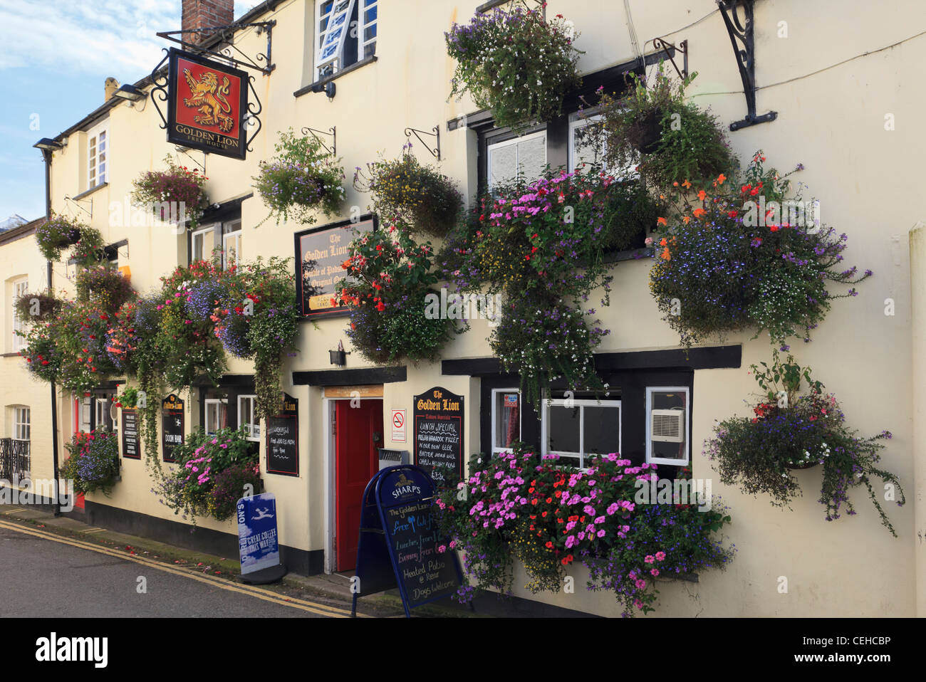 The Golden Lion pub front with flowers in hanging baskets and flower planters. Padstow, Cornwall, England, UK Stock Photo