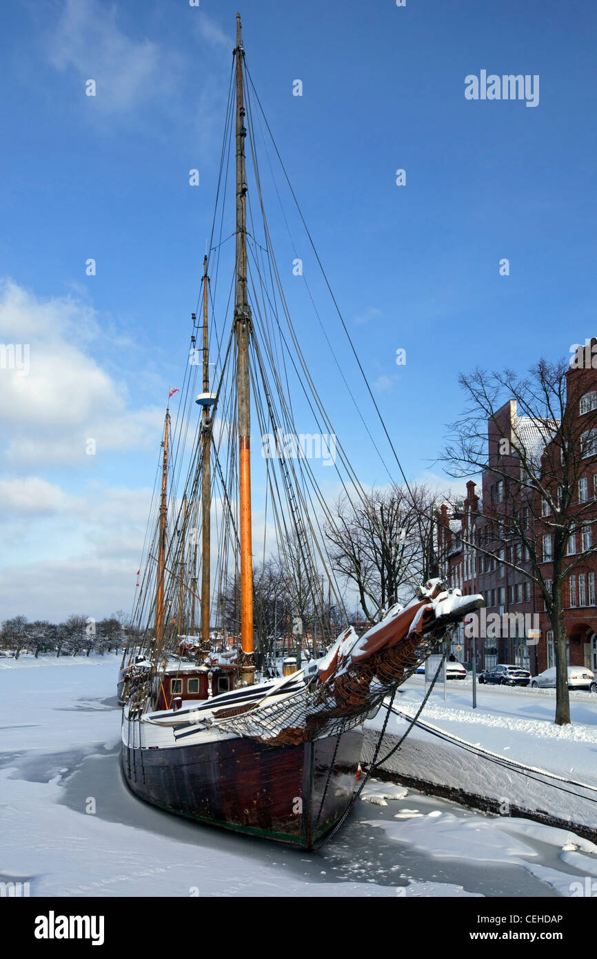 Sailing ship in the snow in winter in the harbour museum at the Hanseatic City of Lübeck, Obertrave, Germany Stock Photo