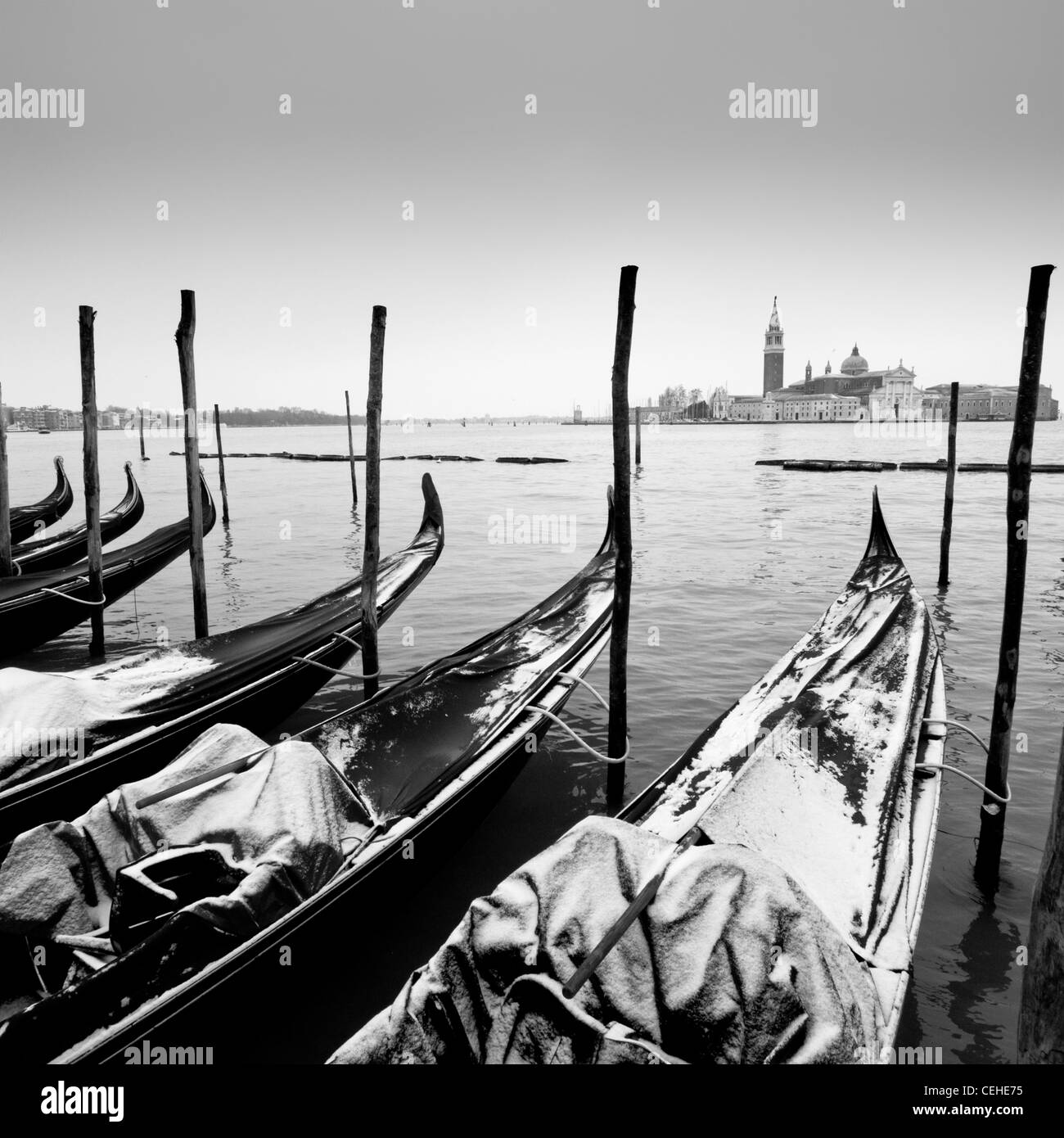Black and white winter view of gondolas covered in snow berthed near San Marco in Venice Italy Stock Photo
