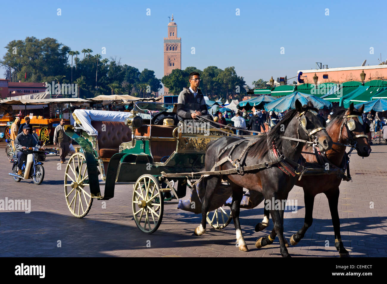 Caleche in Djemaa el Fna sqare with the minaret of the Koutoubia Mosque behind, Marrakech, Morocco, North Africa Stock Photo