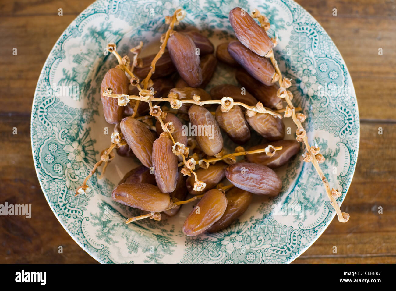 Dried dates in a bowl on a wooden table Stock Photo