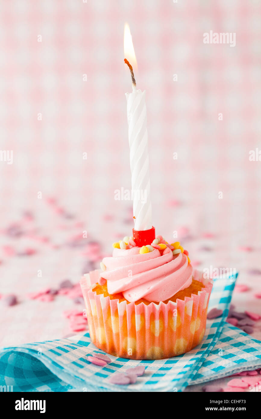 Close-up of a pink muffin with party candle. Studio shot. Stock Photo