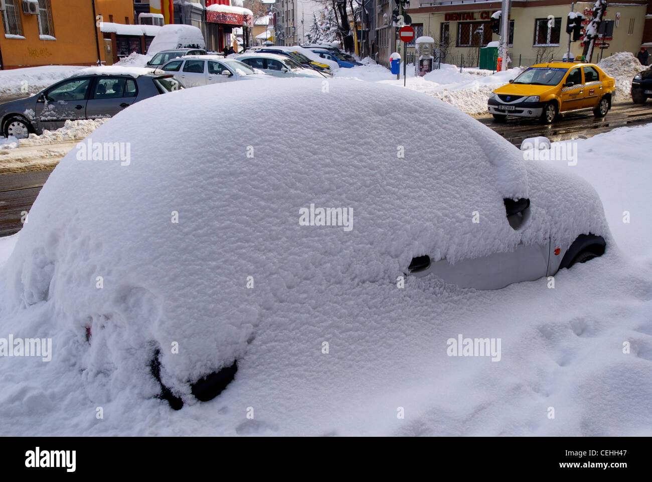 Car completely covered in snow, during the February 2012 snowstorm in Bucharest, Romania. Many people took to the taxis. Stock Photo