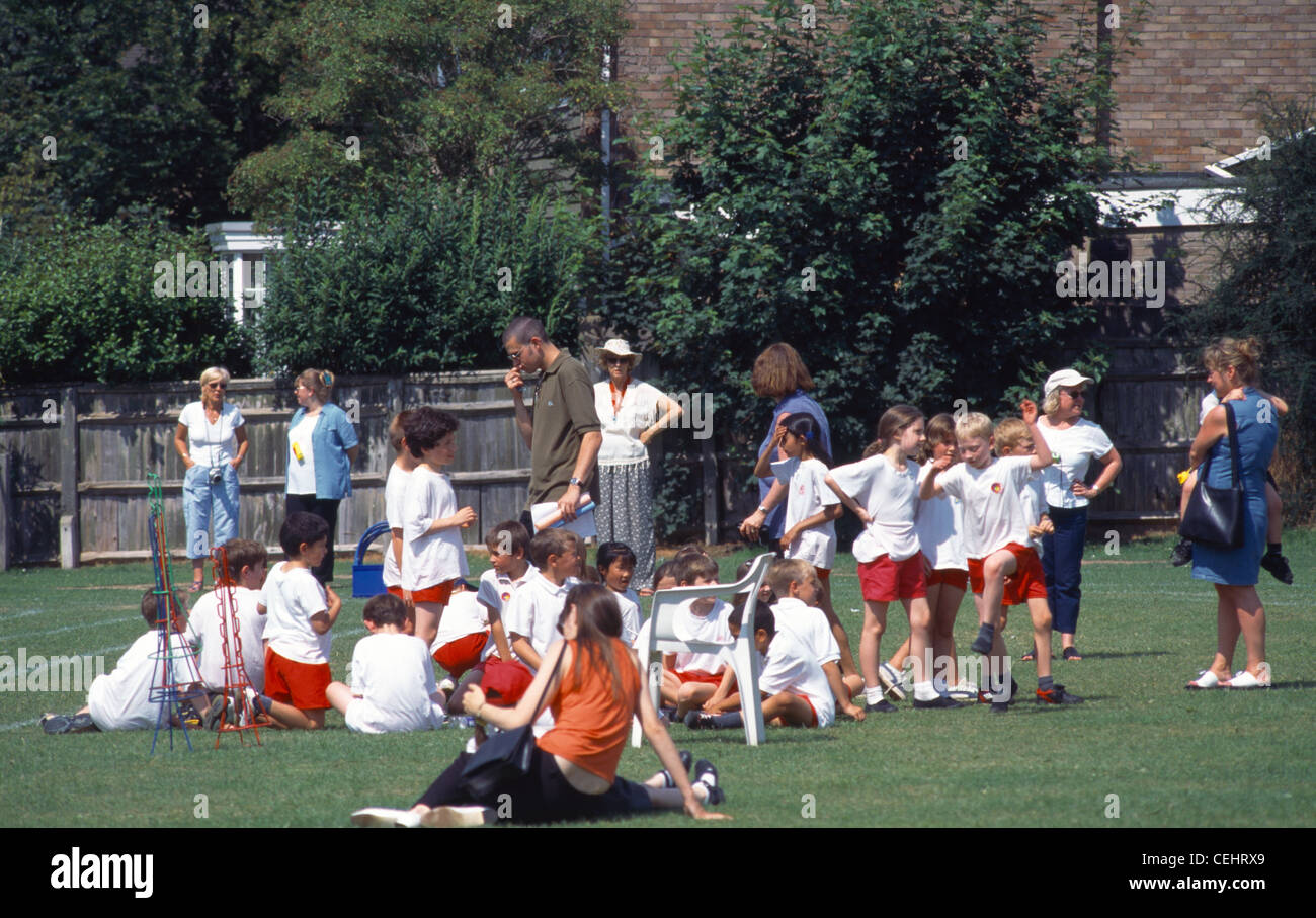 Primary School Sports Day Children And Parents On The Grass Teacher Holding A Whistle Stock Photo