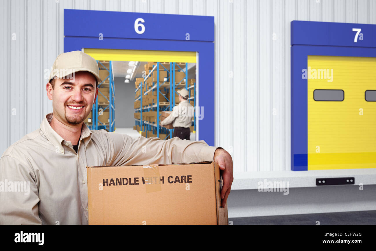 smiling delivery man and warehouse background Stock Photo - Alamy