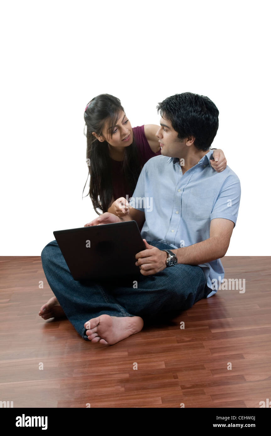 young couple sitting in front of a laptop Stock Photo - Alamy