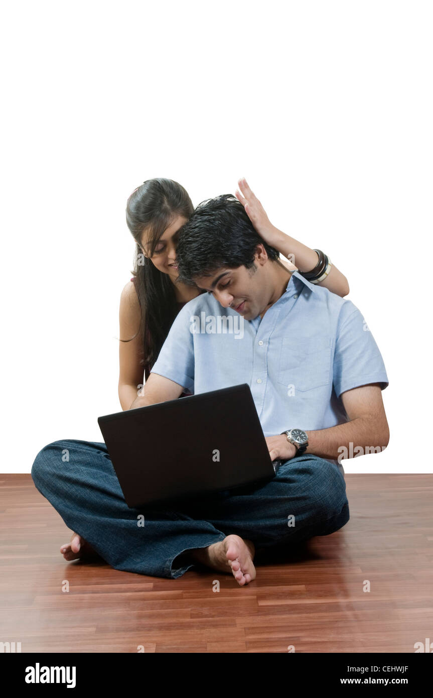 young couple sitting in front of a laptop Stock Photo - Alamy