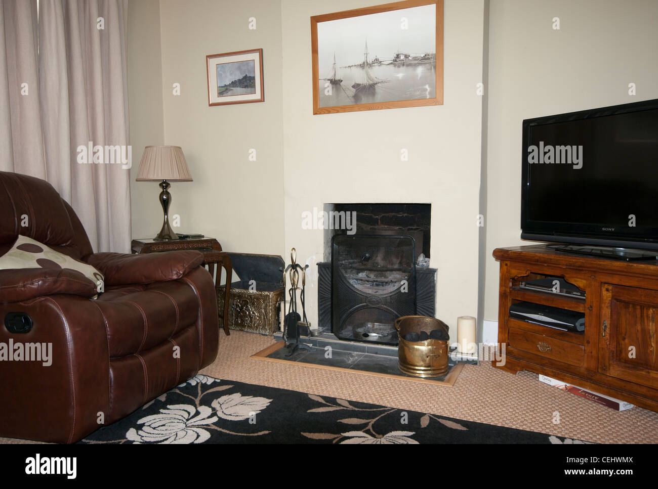 Living Room Lounge In A House With A Leather Armchair Open Fire and a Flat Screen TV Stock Photo