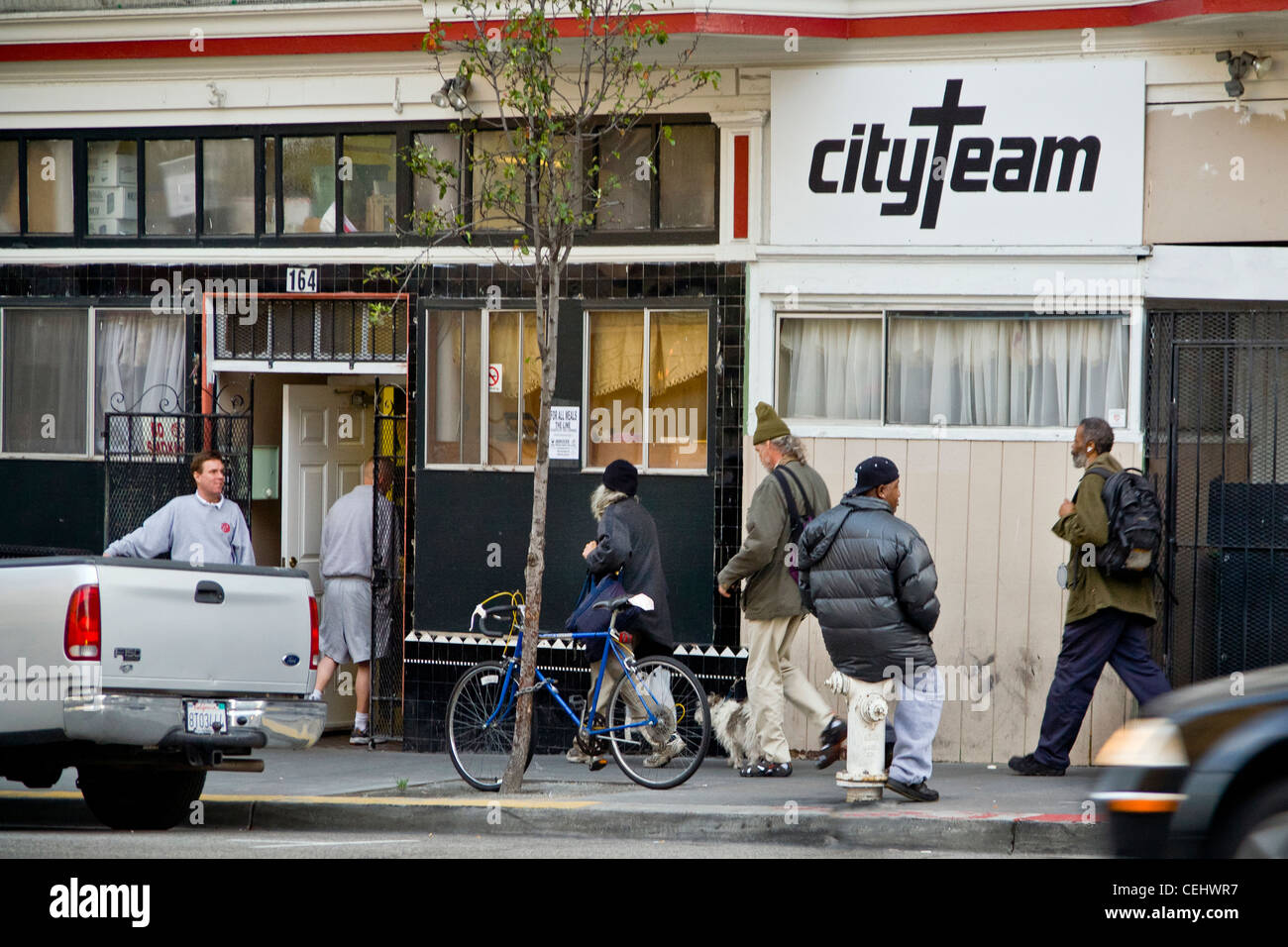 In the evening, homeless people of both sexes enter CityTeam Ministries on 6th Street in San Francisco. Stock Photo