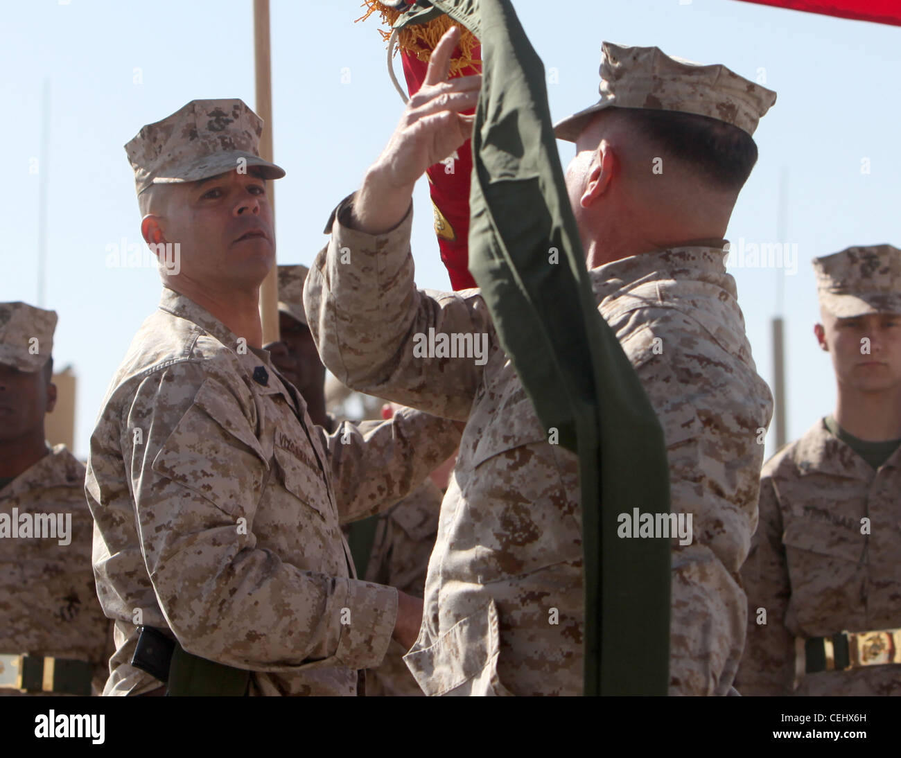 Brig. Gen. John J. Broadmeadow (right), commanding general of 1st Marine Logistics Group (Forward), and Sgt. Maj. Antonio Vizcarrondo (left), the group sergeant major, uncase the unit's colors during a transfer of authority ceremony aboard Camp Leatherneck, Afghanistan, Feb. 15. For the next year, 1st MLG (FWD) will serve as the Logistics Combat Element in southern Afghanistan Stock Photo