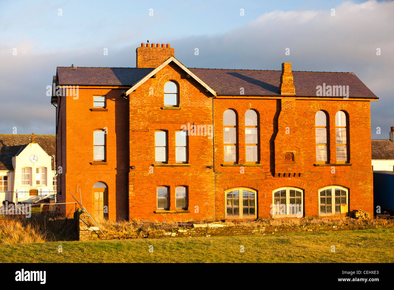 Houses on the seafront in Allonby on the Solway Coast, Cumbria, UK in warm evening light at sunset. Stock Photo