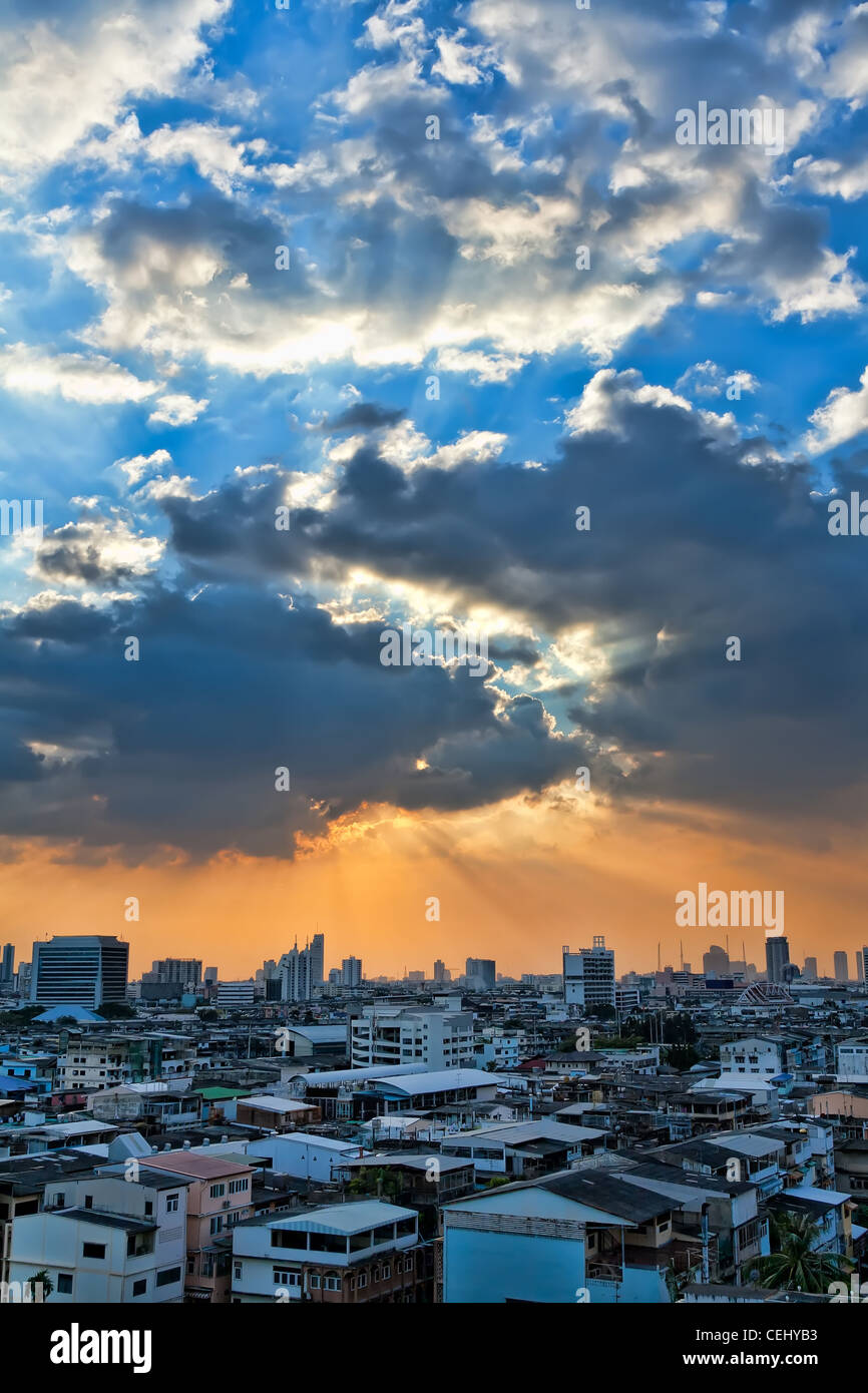 view of the city at sunset, the sun breaks through the clouds Stock Photo