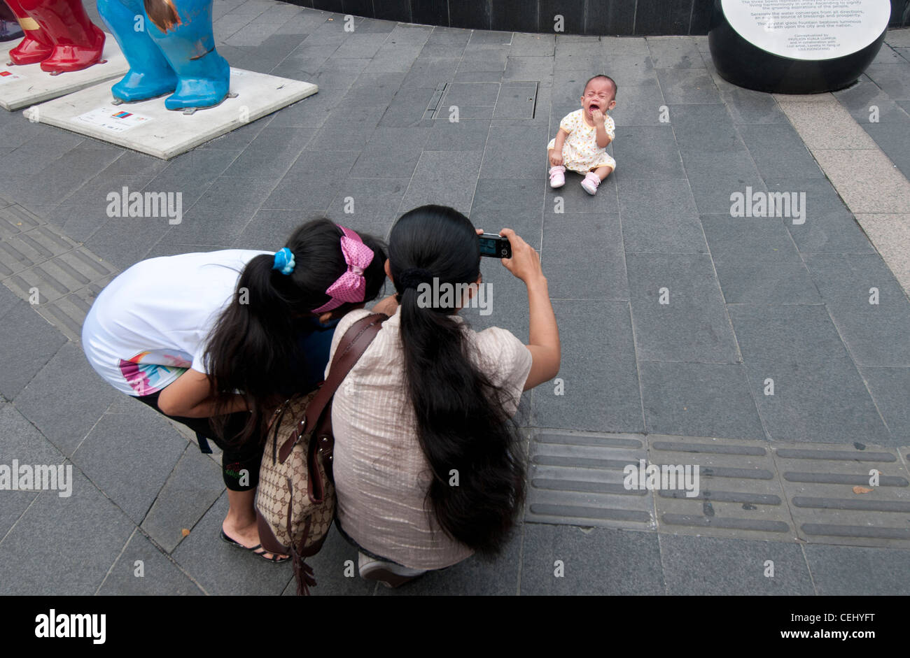 Crying baby being photographed at Bukit Bintang Kuala Lumpur Stock Photo