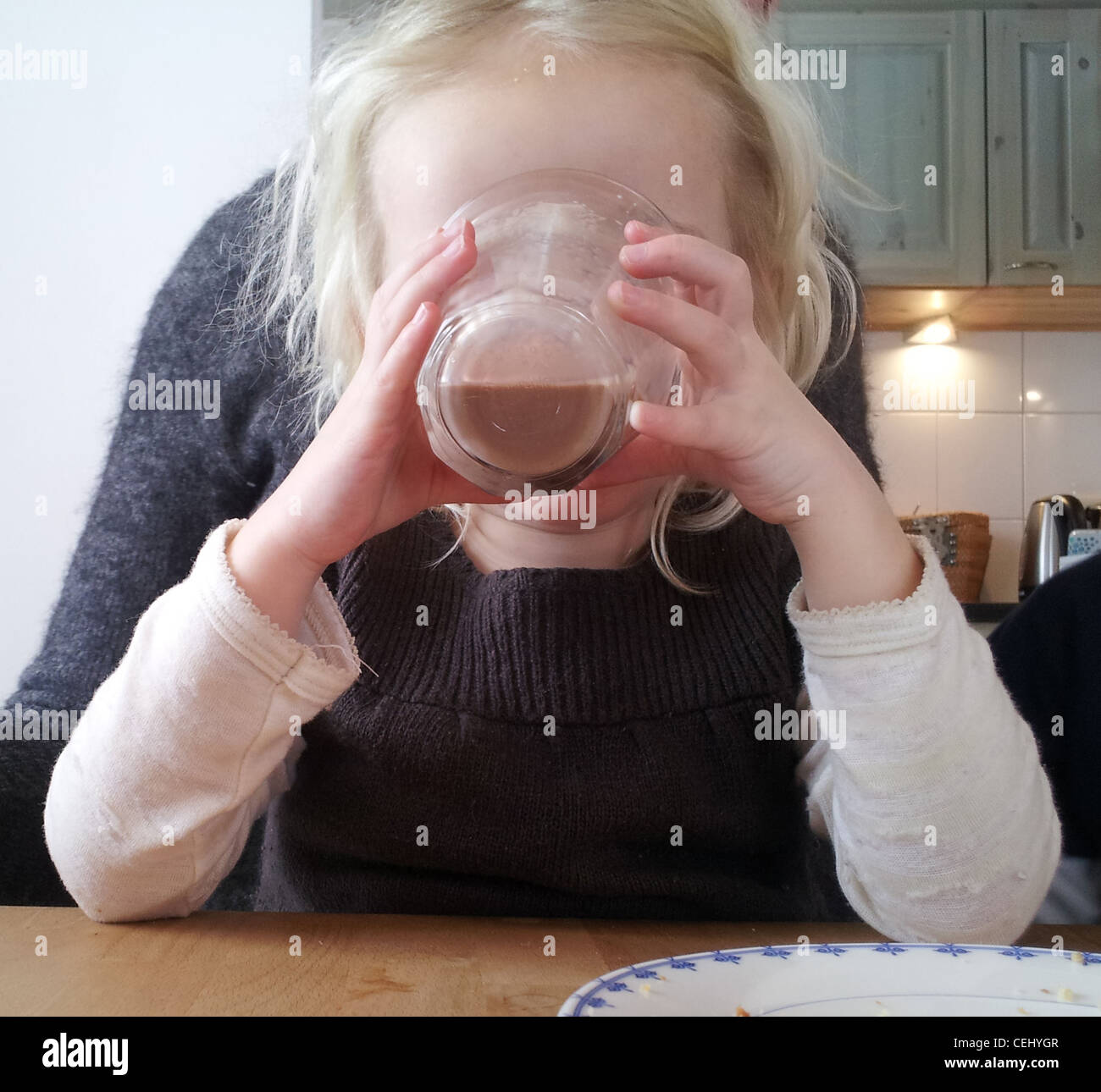 Blond toddler drinking her chocolade milk Stock Photo