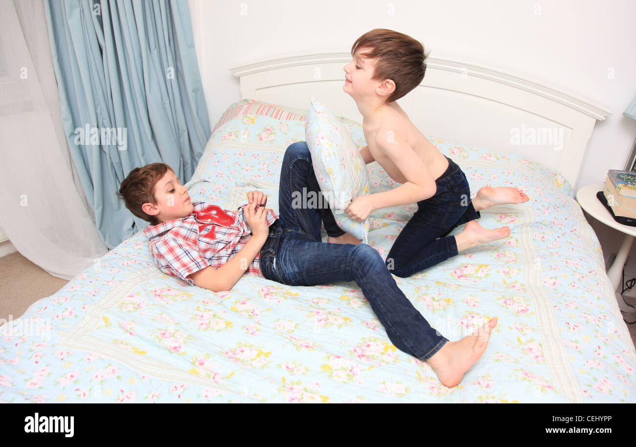 2 boys having a pillow fight on a bed Stock Photo Alamy