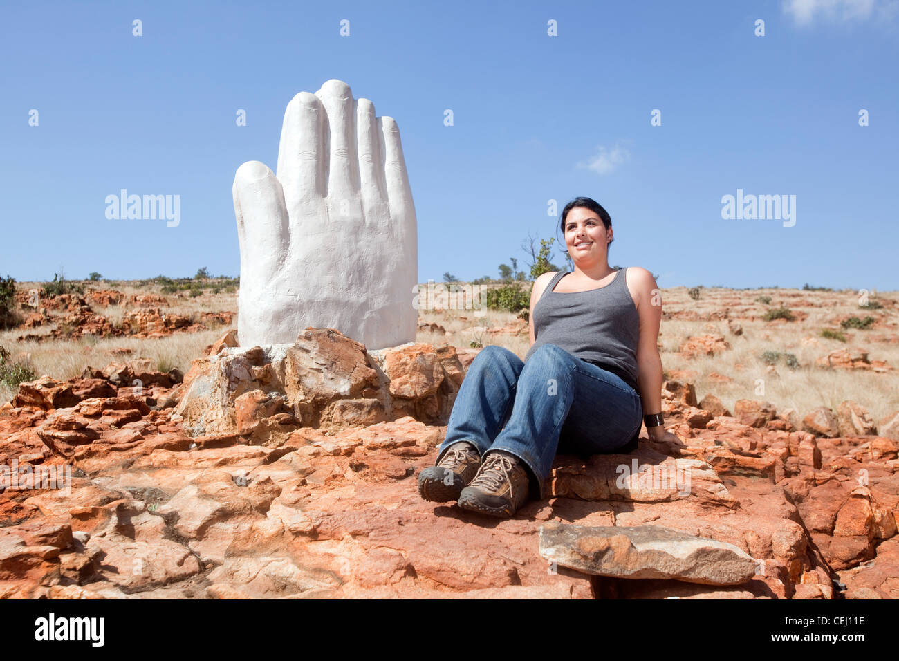 Woman praying at Praying Hands Statue, Magaliesberg,North West Province Stock Photo