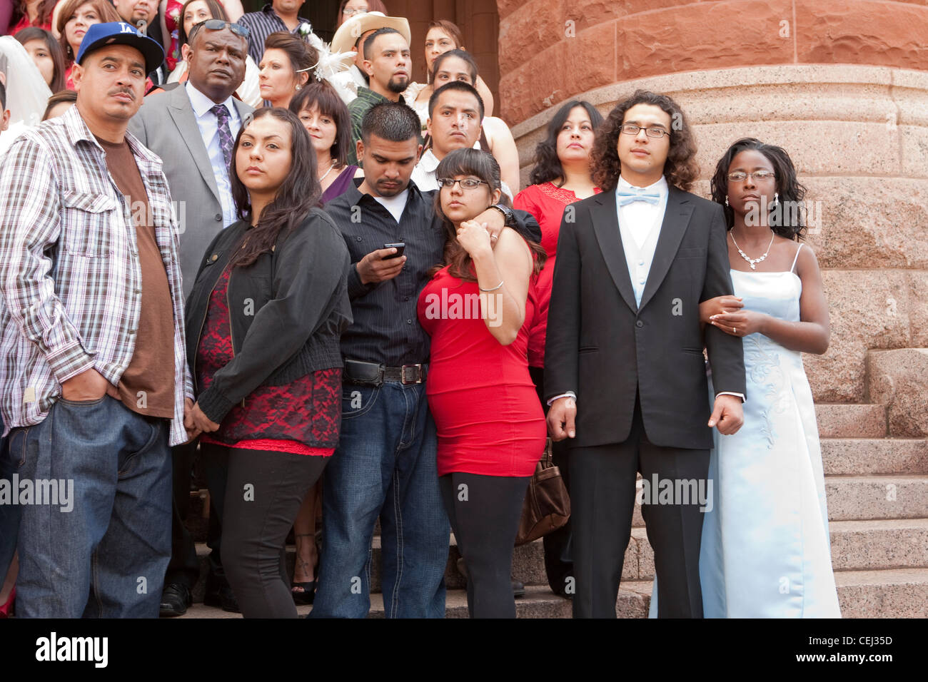 Large group of  couples married during mass wedding ceremony at courthouse where many wore non-traditional informal attire Stock Photo