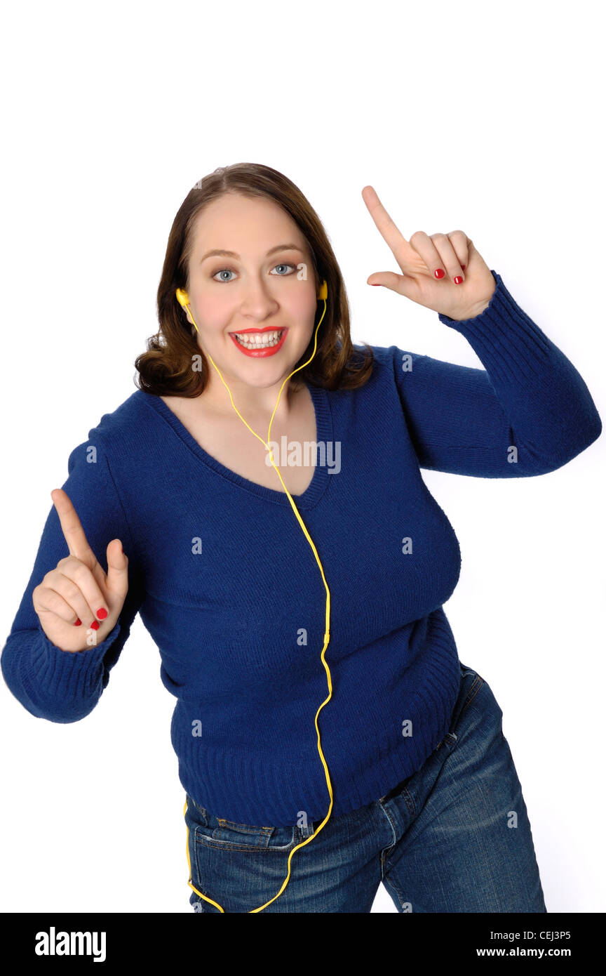 Young lively woman listening to music in an MP3 player and dancing a lively dance. Stock Photo
