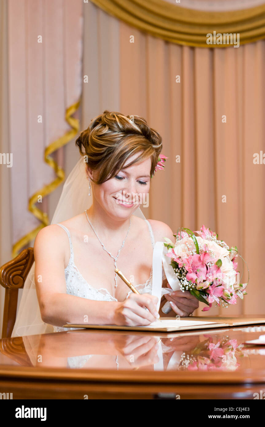 Middle aged bride signing documents during marriage registration Stock Photo