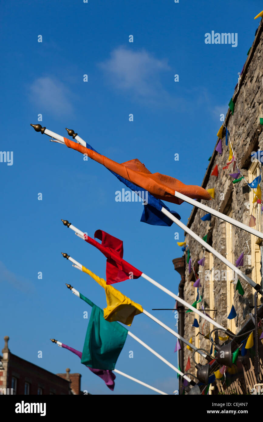 Several different coloured flags flying from flag poles on a building. Stock Photo
