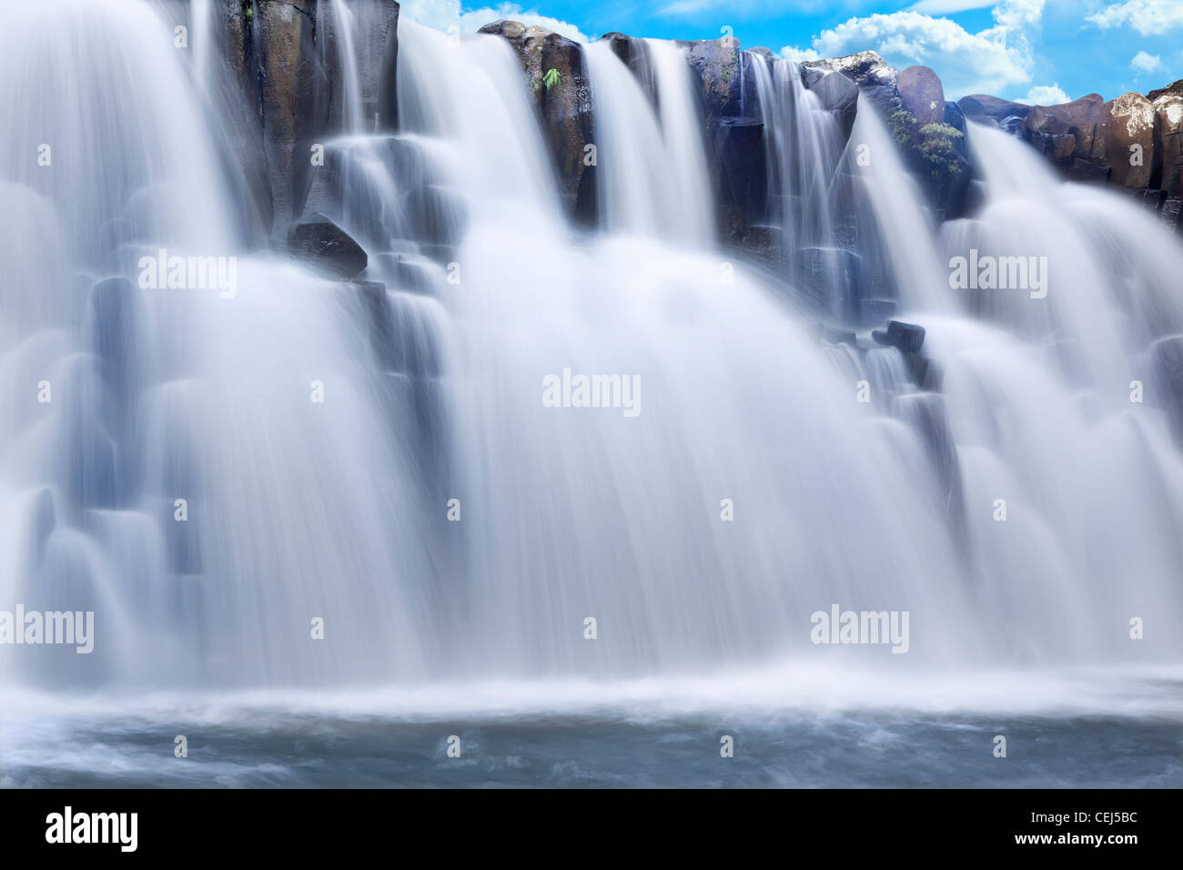 Beautiful waterfall with clear blue sky in background Stock Photo