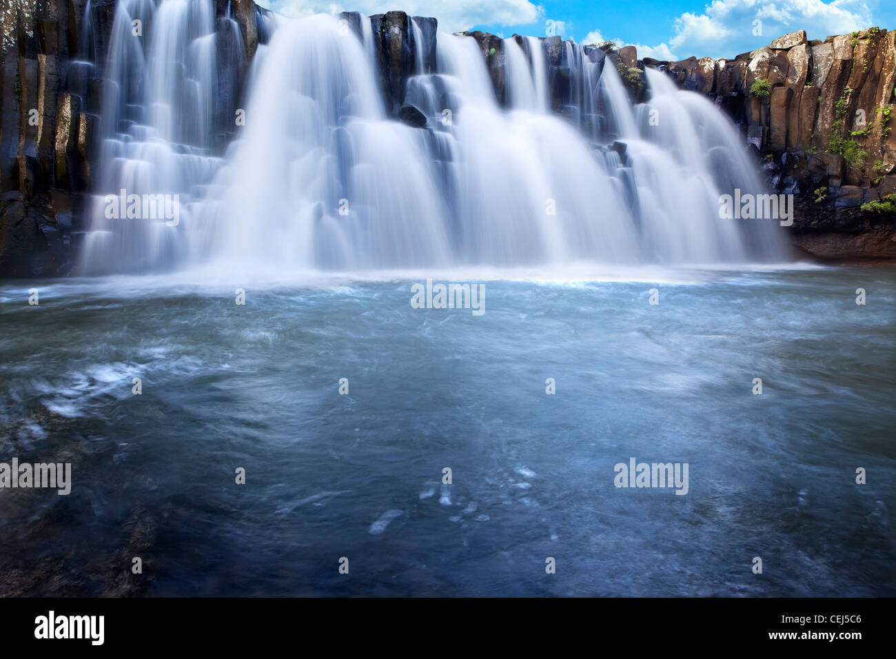 Beautiful waterfall with clear blue sky in background Stock Photo