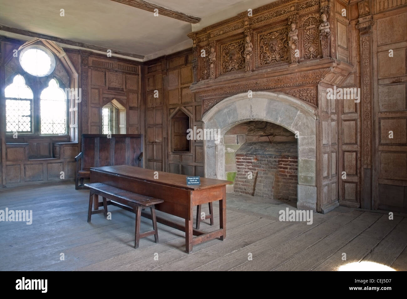 Interior of a room in Stokesay Castle, a fortified manor house at Stokesay, Shropshire, with carved paneling and a fireplace. Stock Photo