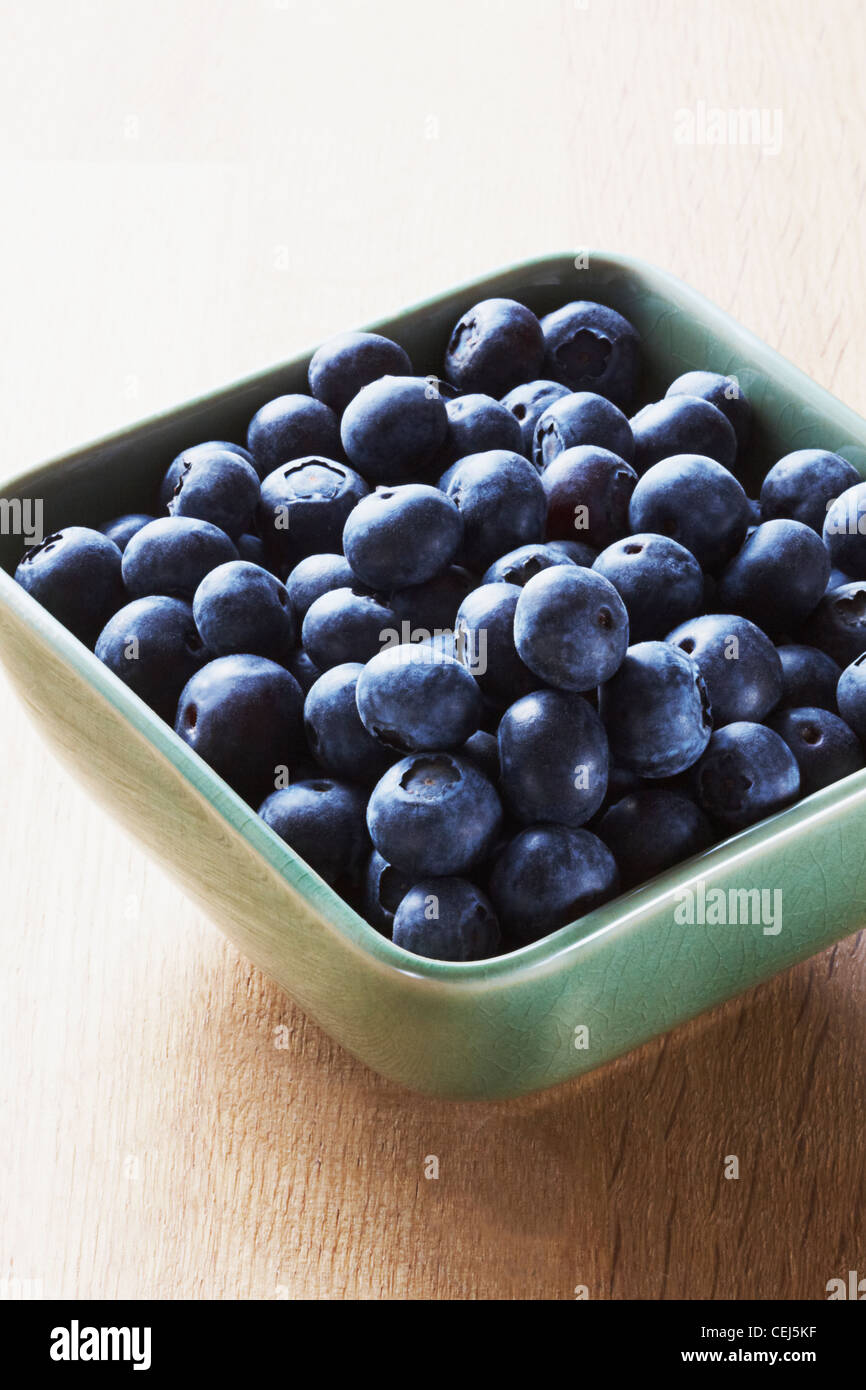 Blueberries in a green bowl on a wooden background Stock Photo