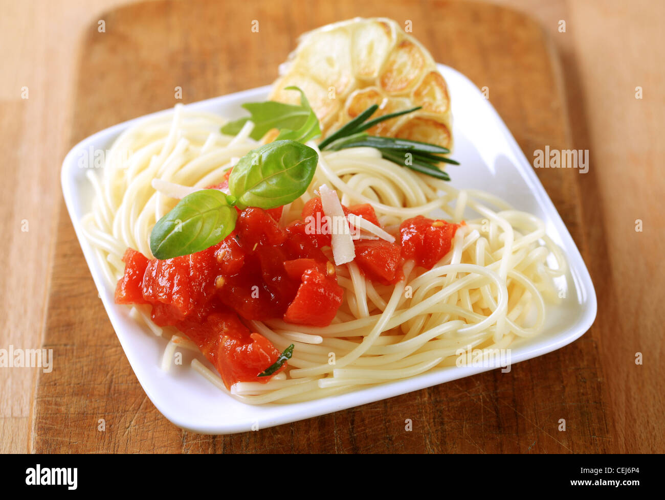 Spaghetti, peeled tomato and baked garlic - closeup Stock Photo
