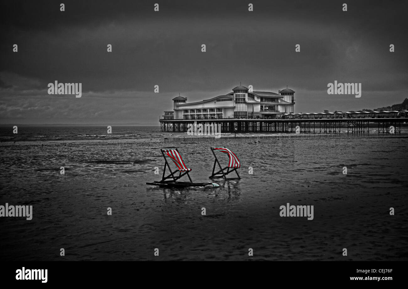Red and white striped deck chairs on Weston Super Mare Beach.   Weston Super Mare Pier.  British Seaside. Stock Photo