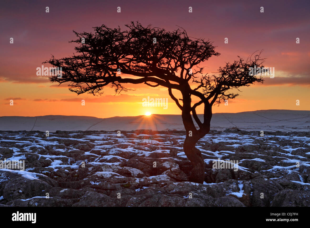Sunset at snow covered limestone pavement near Conistone in Upper-Wharfedale, in the Yorkshire Dales National Park Stock Photo
