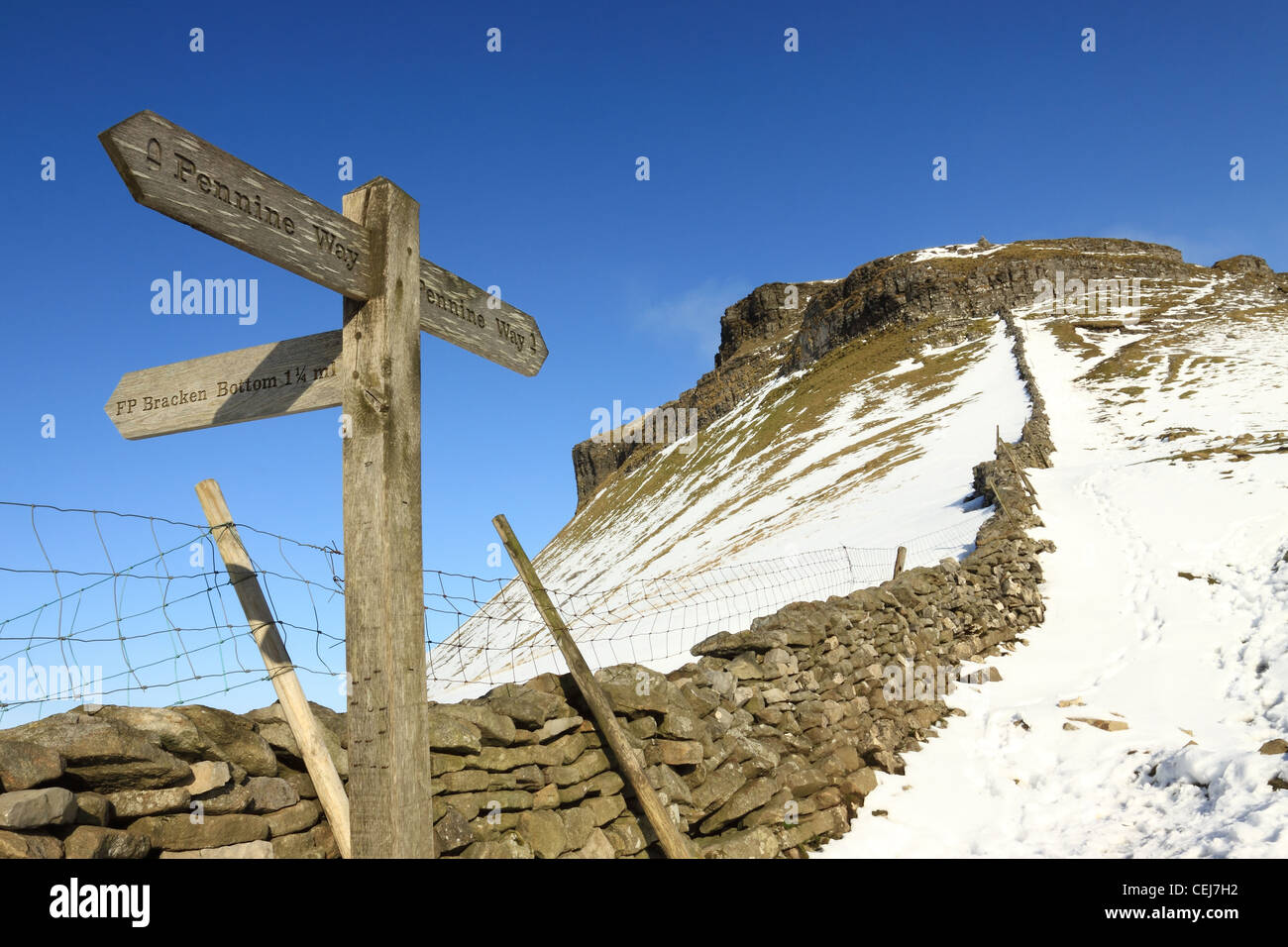 A Pennine Way sign points to the summit of a wintertime Pen-y-ghent, in the Yorkshire Dales national park. Stock Photo